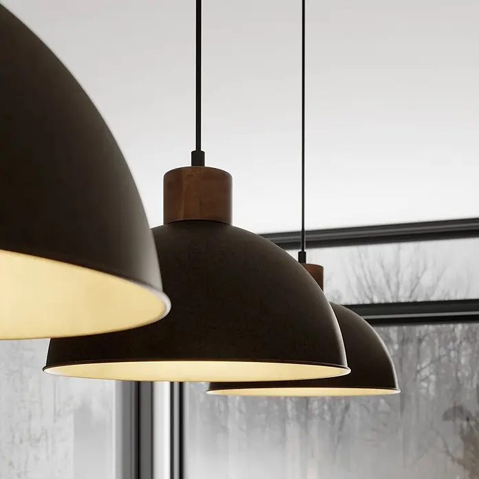 Lindby Pendelleuchte Holgar - alu / grau / zink, grau, holz hell, E27 - Drei dunkle Metall-Pendelleuchten mit Holzdetails hängen in einer Reihe und strahlen warmes Licht vor einem Fensterhintergrund aus.