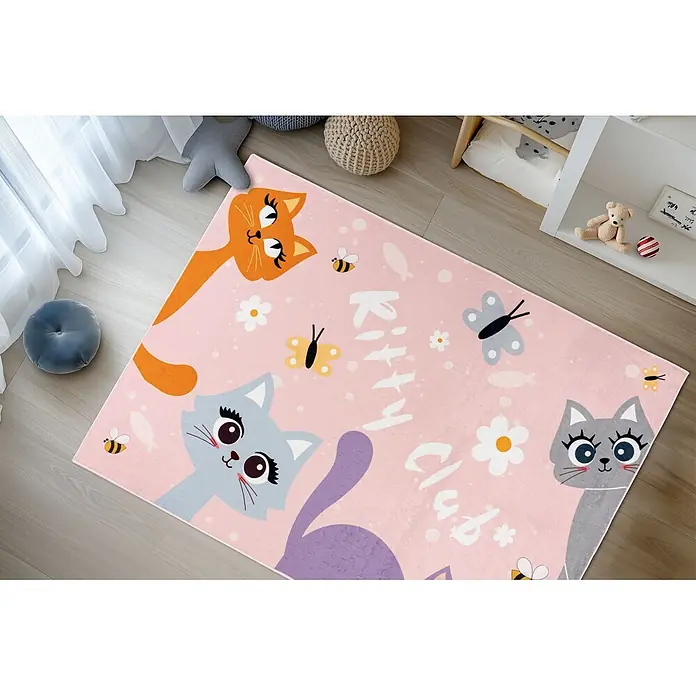 Kayoom Kinderteppich Wonder 129 - Rosa, 160 x 115 cm, 100 % Polyester - Rosa Kinderteppich mit Comic-Katzen (orange, blau, grau), Schmetterlingen, Bienen, Blumen und „Kitty Club“-Text auf einem Holzfußboden.