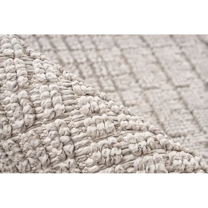Kayoom Fransenteppich Reef 125 - Silber, 150 x 80 cm, 100 % Polypropylen - Nahaufnahme eines strukturierten Teppichs mit erhabenem hellgrau-weißem Schlingenflor.