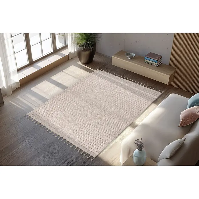 Kayoom Fransenteppich Reef 225 - Beige, 150 x 80 cm, 100 % Polypropylen - Beiger Teppich mit strukturierten Bogenmustern und Quasten auf Holzfußboden in sonnigem Wohnzimmer.