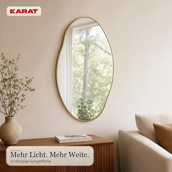 Floordirekt Wandspiegel Lena - 60,1 x 90,1 cm - Ein unregelmäßig geformter, goldgerahmter Spiegel hängt an einer hellen Wand, reflektiert einen Fensterblick und bringt Licht in den Raum.