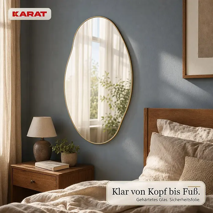 Floordirekt Wandspiegel Lena - 60,1 x 90,1 cm - Unregelmäßig geformter Spiegel mit goldenem Rahmen an einer blauen Wand im Schlafzimmer, reflektiert ein Fenster. Aus gehärtetem Glas mit Sicherheitsfolie.