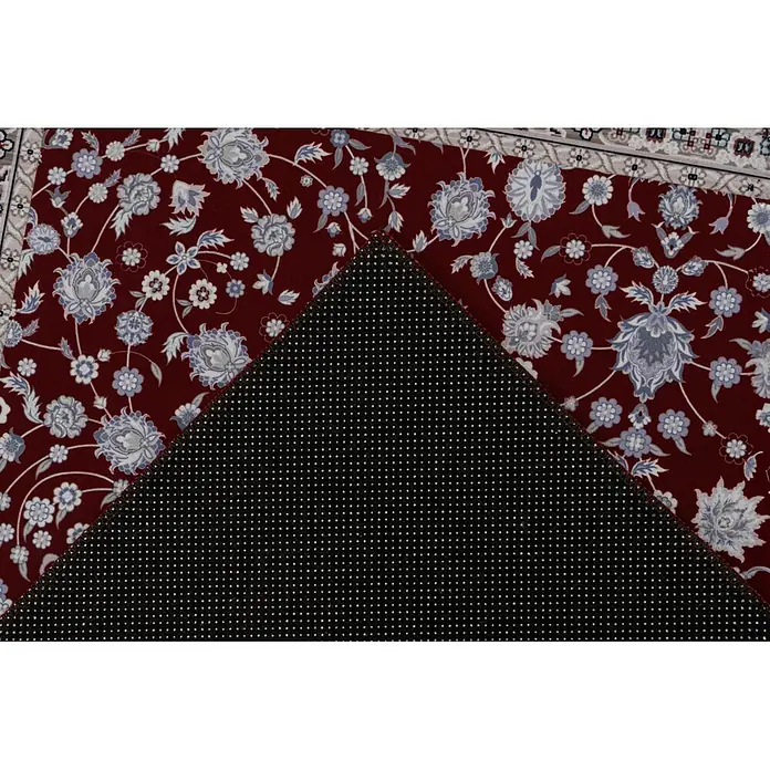 Kayoom Kurzflorteppich Rocks 125 - Rot, 290 x 200 cm, 100 % Polyester - Roter Teppich mit Blumenmuster, eine Ecke umgeklappt, die die schwarze rutschfeste Punktbeschichtung zeigt.