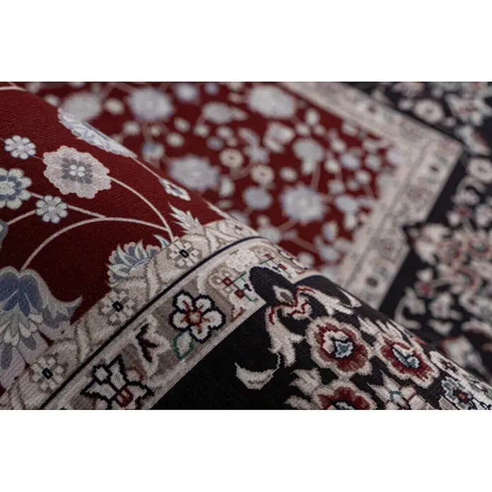 Kayoom Kurzflorteppich Rocks 125 - Rot, 290 x 200 cm, 100 % Polyester - Zwei verzierte Teppiche, ein roter und ein schwarzer, teilweise aufgerollt, um ihre detaillierten Blumenmuster zu zeigen.