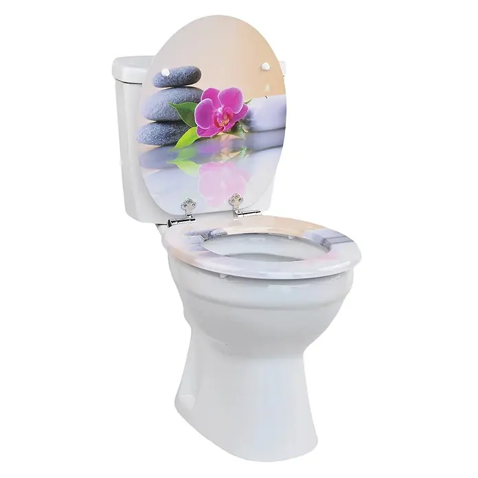 SAINOS WC-Sitz MDF WC-Sitz, Universal-O-Form, Absenkautomatik, Unten - MDF, Mehrfarbig, Mit Absenkautomatik - Weißes WC mit dekorativem Sitz und Deckel, der ein Spa-Design mit Steinen, einer Orchidee und einer Kerze zeigt.