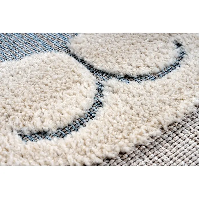 Kayoom Kinderteppich Modena 424 - Grau, 170 x 120 cm, 100 % Polypropylen - Nahaufnahme eines cremefarbenen und blauen gemusterten Teppichs mit kontrastierenden Florhöhen.