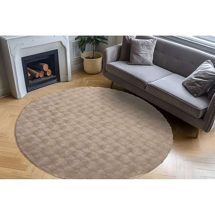 Kayoom Fellteppich Royal Glow 825 - Taupe, Durchmesser: 120 cm, 80 % Polyester, 20 % Baumwolle - Runder, hellbrauner Steppteppich auf Holzfußboden, teilweise unter Sofa.