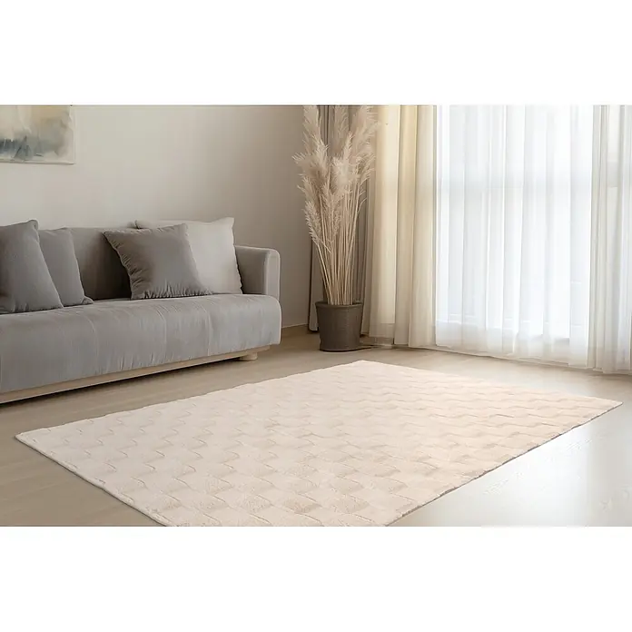 Kayoom Hochflorteppich Botany 625 - Beige, 150 x 80 cm, 100 % Polyester - Heller beiger Teppich mit dezentem geometrischem Muster auf hellem Holzfußboden in einem Wohnzimmer.