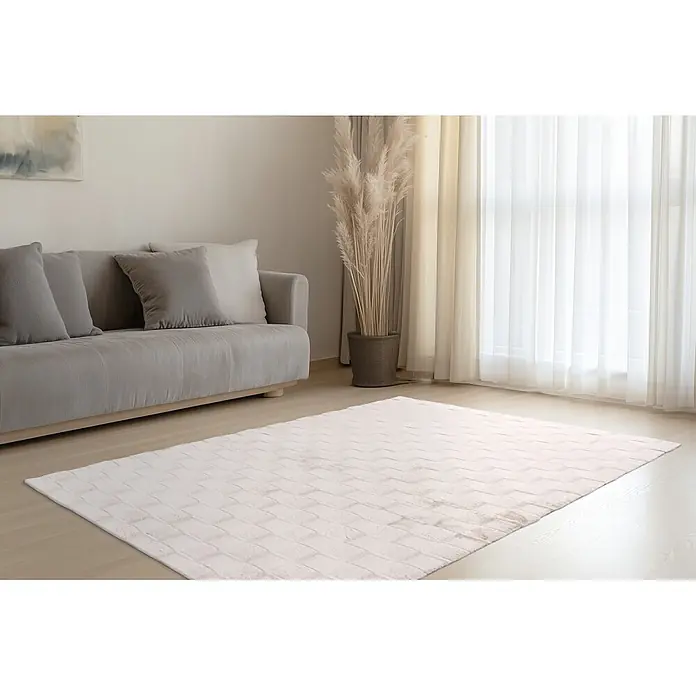 Kayoom Hochflorteppich Botany 625 - Helltaupe, 230 x 160 cm, 100 % Polyester - Cremefarbener Teppich mit geprägtem Blockmuster auf hellem Holzfußboden, in einem Wohnzimmer.