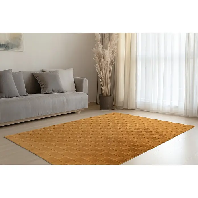 Kayoom Hochflorteppich Botany 625 - Gelb, 230 x 160 cm, 100 % Polyester - Senfgelber Teppich mit geprägtem geometrischem Muster auf hellem Holzboden im Wohnzimmer.