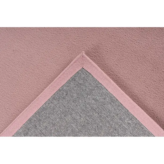 Kayoom Fellteppich Cross 425 - Pastellrosa, 230 x 160 cm, 100 % Polyester - Rosa flauschiger Teppich mit umgeschlagener Ecke, die die gewebte Rückseite und rosa Einfassung zeigt.