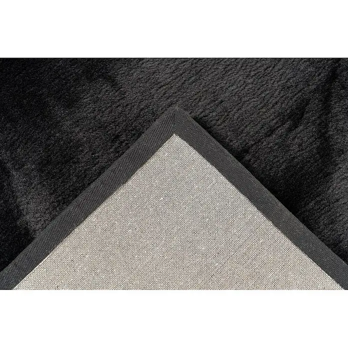 Kayoom Fellteppich Cross 425 - Schwarz, Durchmesser: 160 cm, 100 % Polyester - Schwarzer Plüschteppich mit umgeschlagener Ecke, die die gewebte Rückseite zeigt.