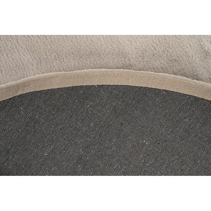 Kayoom Fellteppich Cross 425 - Taupe, Durchmesser: 120 cm, 100 % Polyester - Nahaufnahme eines zweifarbigen Teppichs, der seine hellbeige flauschige Oberfläche, gewebte Kante und dunkelgraue gewebte Rückseite zeigt.