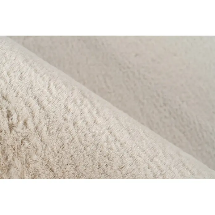 Kayoom Fellteppich Cross 425 - Creme, 230 x 160 cm, 100 % Polyester - Helles beiges Kunstfellgewebe, das seine weiche, plüschige Textur in gefaltetem Zustand zeigt.