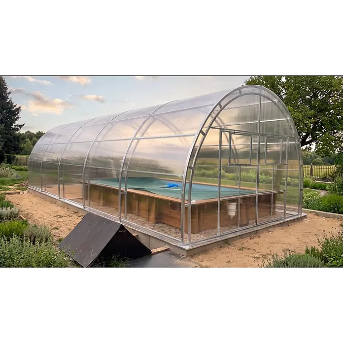 Garten Dream Poolüberdachung Grand Oasis, 4mm Polycarbonat - L x B x H: 800 x 400 x 289 cm - Ein bogenförmiges Gewächshaus mit lichtdurchlässigen Platten, das einen Swimmingpool mit Holzverkleidung in einem Garten abdeckt.
