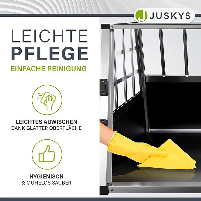 Juskys Transportbox - 51 x 89 x 70 cm, Aluminium, Schwarz / Silber - Eine Hand mit gelbem Handschuh wischt die glatte, dunkle Oberfläche einer Hundebox mit einem gelben Tuch ab, was die einfache Reinigung hervorhebt.