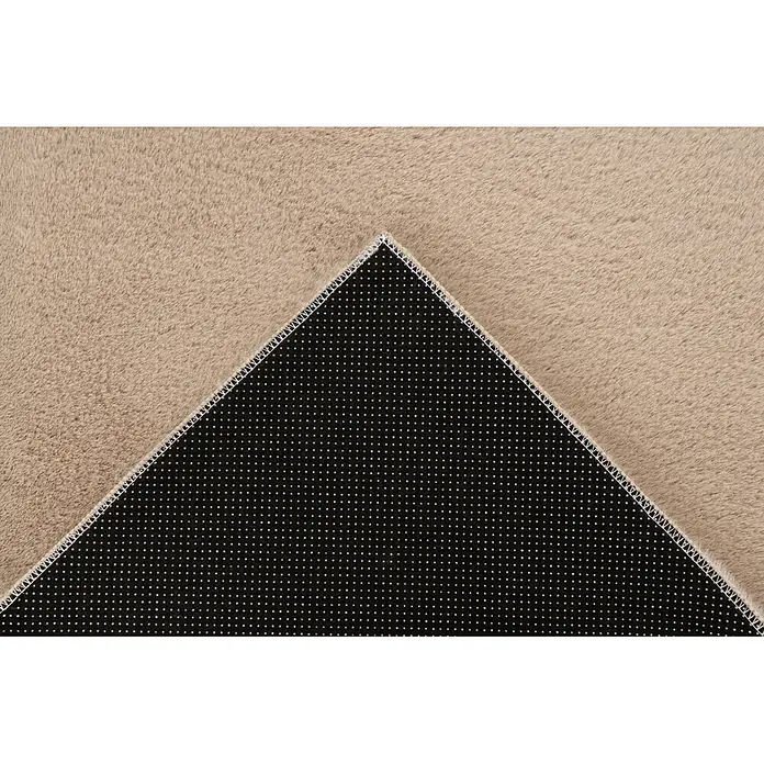 Kayoom Fellteppich Emperor 525 - Beige, 170 x 120 cm, 100 % Polyester - Beiger Kunstfellteppich mit umgeklappter Ecke, die die schwarze Anti-Rutsch-Unterseite zeigt.