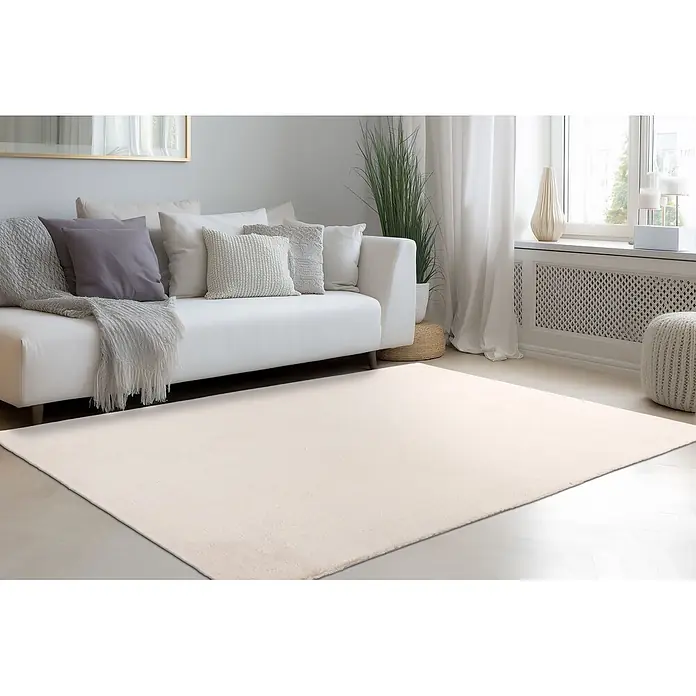 Kayoom Fellteppich Emperor 525 - Helltaupe, 290 x 200 cm, 100 % Polyester - Heller, cremefarbener/beiger Teppich in einem gemütlichen Wohnzimmer, unter einem weißen Sofa platziert.