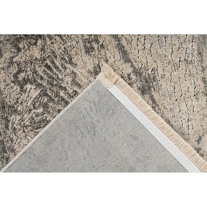 Kayoom Kurzflorteppich Adela 525 - Grau, 170 x 120 cm, 100 % Polypropylen - Nahaufnahme eines beigefarbenen und dunkelgrau gemusterten Teppichs, dessen Ecke die gewebte Rückseite und Fransen zeigt.