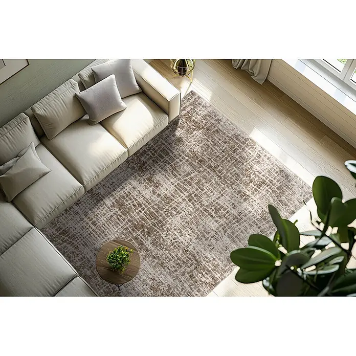 Kayoom Kurzflorteppich Amora 260 - Braun, 150 x 80 cm, 100 % Polyester - Abstrakter brauner und beiger Teppich unter einem hellen Sofa in einem modernen Wohnzimmer.