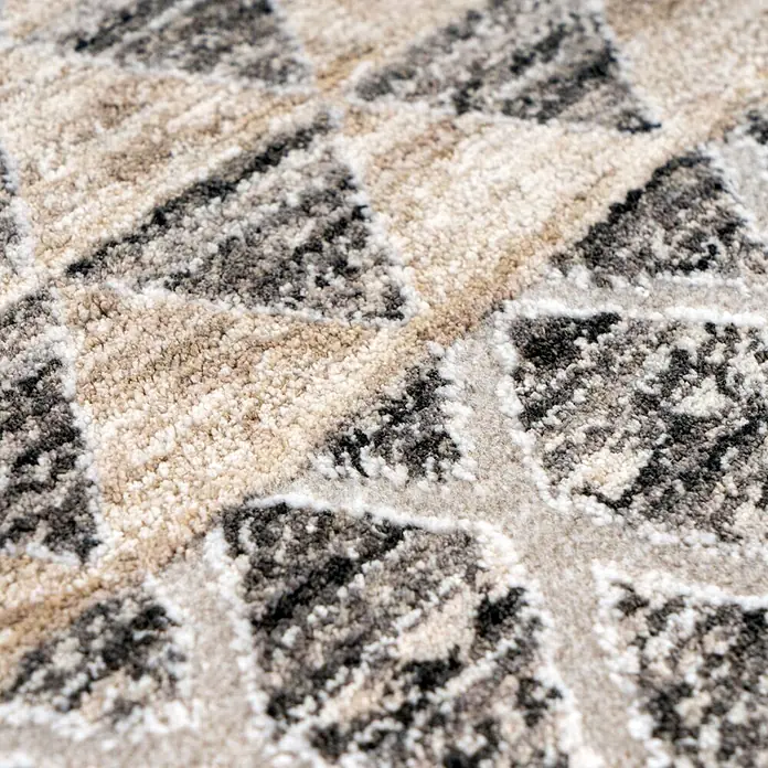 Kayoom Kurzflorteppich Amora 261 - Grau, 300 x 240 cm, 100 % Polyester - Nahaufnahme eines texturierten Teppichs mit unregelmäßigem Geometriemuster in Hellbeige und Dunkelgrau.