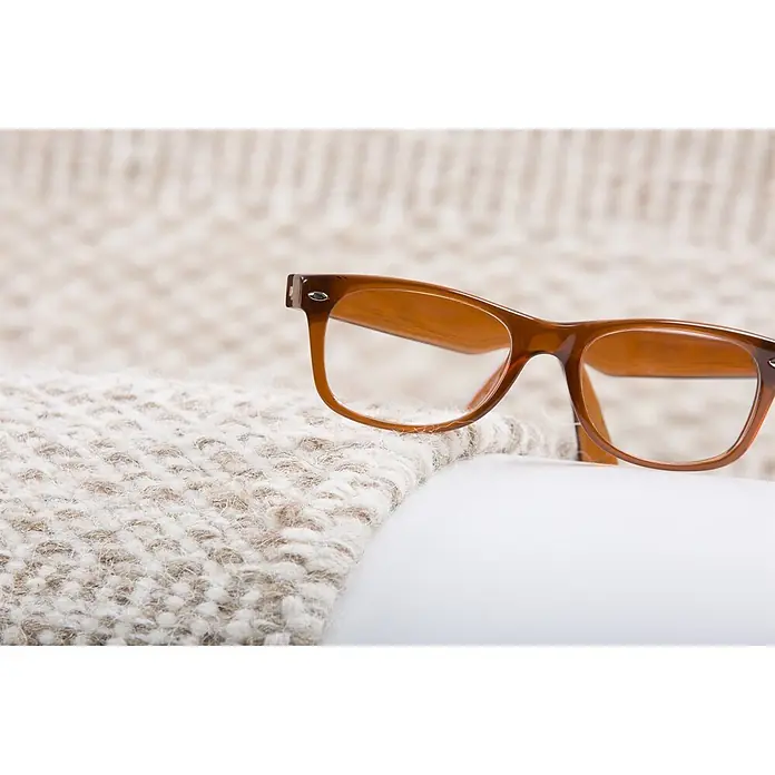 Kayoom Wollteppich Bombay 343 - Beige, 170 x 120 cm, 100 % Wolle - Braun umrandete Brille, die auf einem hellen Strickstoff und einer weißen Oberfläche liegt.
