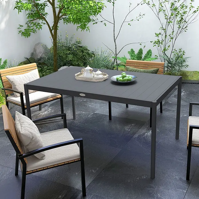 Furnicato Gartentisch - L x B x H: 145 x 90 x 74 cm, Rechteckig, Dunkelgrau - Dunkelgrauer Gartentisch mit schwarzgerahmten Stühlen aus hellem Holz und beigen Kissen auf einer Terrasse mit Pflanzen.