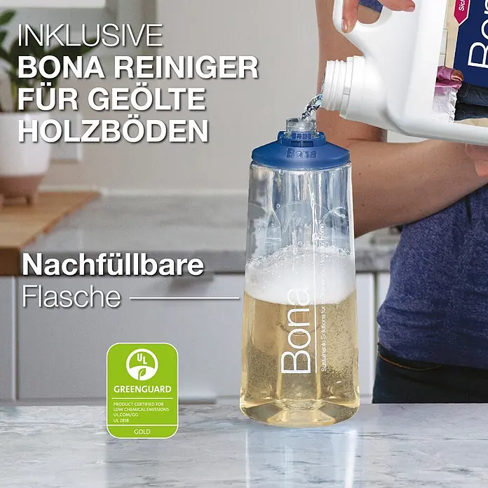 Bona Spray Mop Premium für geölte Holzfußböden - 1 x Spray Mop, 1 x nachfüllbare Kartusche mit 850 ml Reinigungsmittel, 1 x Microfaser-Reinigungspad - Eine Person füllt eine klare Bona Reinigerflasche für geölte Holzböden aus einem weißen Behälter nach. Das Produkt ist GREENGUARD Gold zertifiziert.