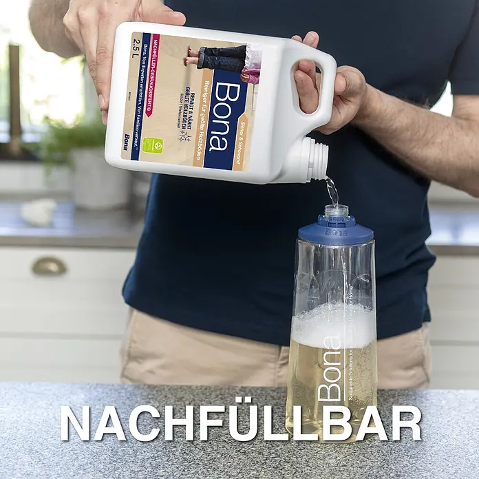 Bona Bodenreiniger Reiniger für geölte Böden - 850 ml, Kartusche - Eine Person füllt Bona Bodenreiniger aus einem großen weißen Nachfüllbehälter in eine klare Bona Sprühflasche um.
