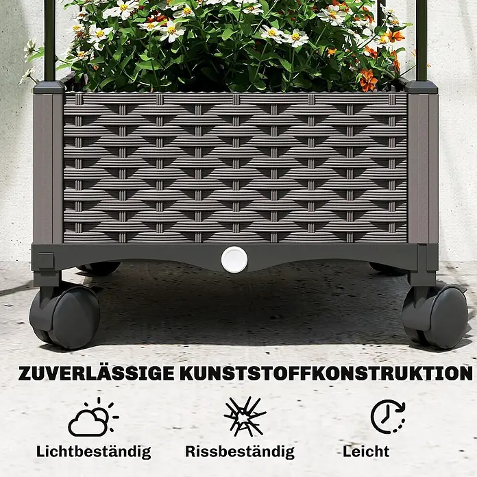 Furnicato Hochbeet - 185 x 40 x 185 cm, Verbundwerkstoff, Schwarz - Grauer Pflanzkasten aus Kunststoff mit Flechtoptik und Rollen, gefüllt mit weißen und orangen Blumen, auf Betonboden.
