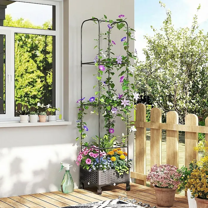 Furnicato Hochbeet - 185 x 40 x 185 cm, Verbundwerkstoff, Schwarz - Schwarzes Metallspalier mit dunkelgrauem Pflanzkübel auf Rollen, gefüllt mit bunten Blumen und Rankpflanzen auf einer Terrasse.