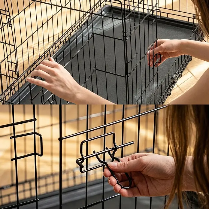 belviona Transportbox - 92 x 58 x 64 cm, Kunststoff, schwarz - Schwarze Draht-Hundebox, Hände zeigen den sicheren Riegelmechanismus.