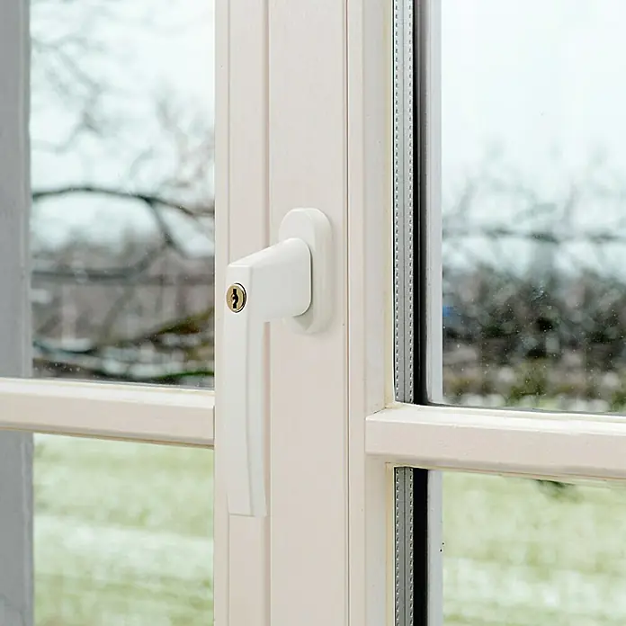 Abus Fenstergriff FG 210 - Weiß, Abschließbar - Nahaufnahme eines weißen Fenstergriffs mit Schloss vor einem verschwommenen Hintergrund einer Außenansicht.