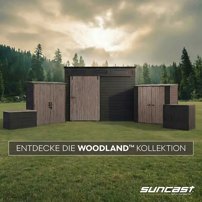 Suncast Auflagenbox - 147 x 74 x 74 cm, Kunststoff, Anthrazit - Dunkelgraue Woodland Schuppen und Boxen mit Holzoptik-Türen auf Gras vor einem Wald.