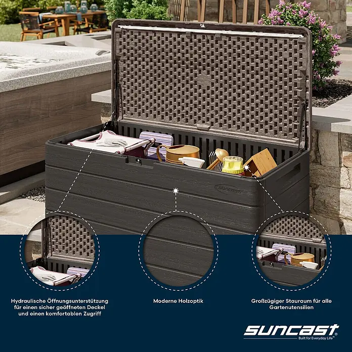 Suncast Auflagenbox - 147 x 74 x 74 cm, Kunststoff, Anthrazit - Dunkelbraune Outdoor-Aufbewahrungsbox in Holzoptik, geöffnet und mit Gartengeräten gefüllt, mit hydraulischer Deckelstütze und geräumigem Innenraum auf einer Terrasse.