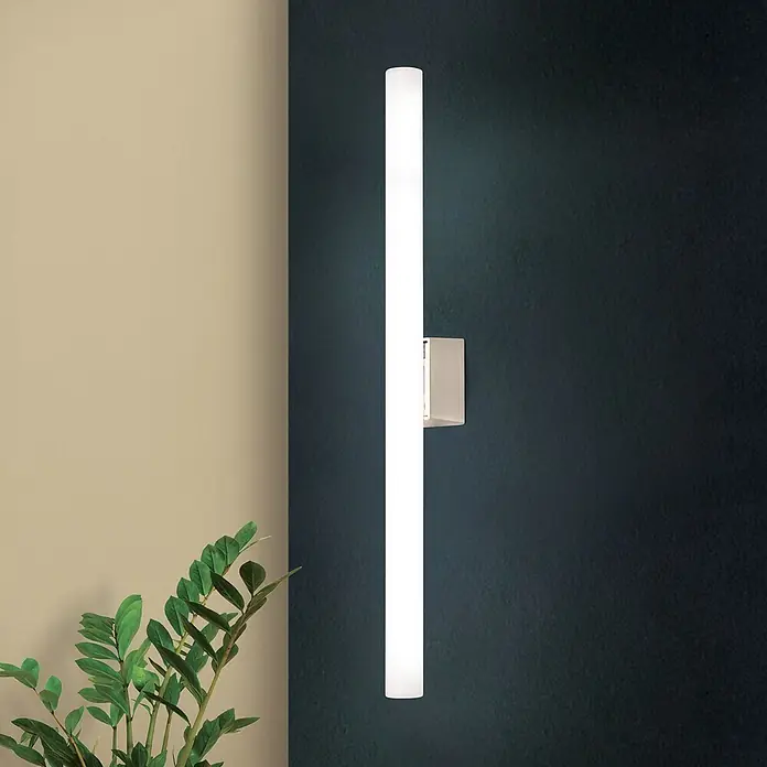 Orion Leuchten Wandleuchte - 60 W, L x B x H: 7 x 50 x 3,8 cm, S14d - Vertikale rechteckige Wandleuchte mit gebürsteter Metallbasis, beleuchtet eine dunkle Wand neben einer Pflanze.