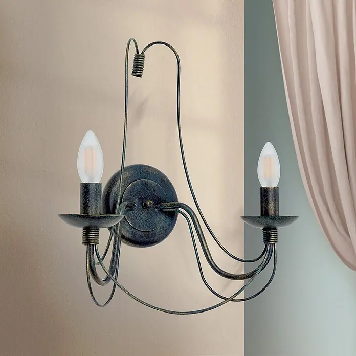 Orion Leuchten Wandleuchte - 40 W, L x B x H: 19 x 39 x 40 cm, E14 - Gealterte dunkle Metall-Wandleuchte mit zwei Leuchtmitteln, geschwungenen Armen und zwei kerzenförmigen LED-Lampen, an einer Wand montiert.
