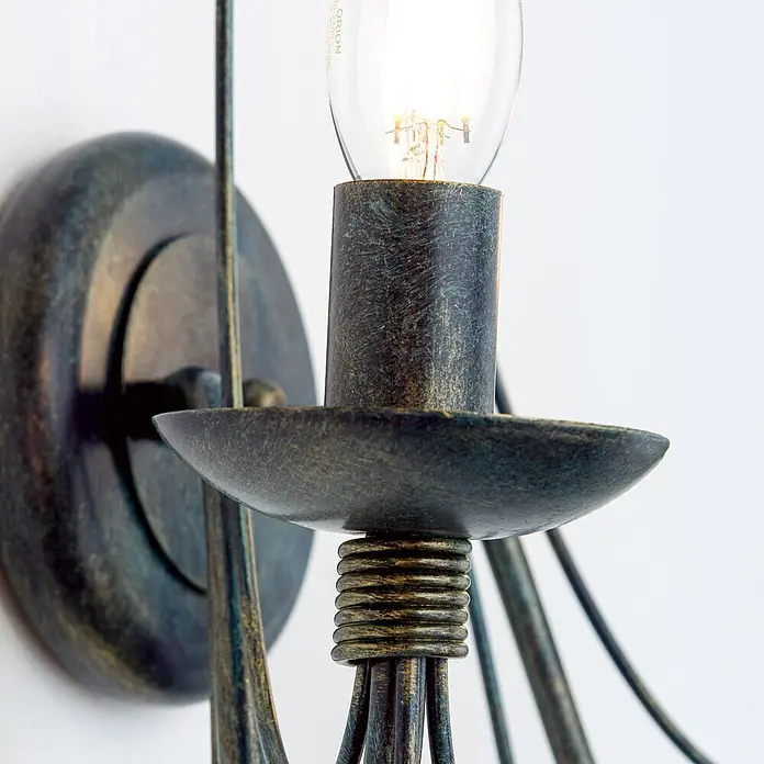 Orion Leuchten Wandleuchte - 40 W, L x B x H: 19 x 39 x 40 cm, E14 - Nahaufnahme einer Wandleuchte aus gealtertem Metall mit leuchtender Glühbirne in dekorativer Fassung und Schale.