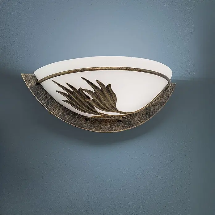 Orion Leuchten Wandleuchte - 60 W, L x B x H: 15 x 27,5 x 9 cm, E14 - Eine antike bronzene Wandleuchte mit mattweißem Glasschirm und dekorativen Blattdetails an einer blauen Wand.