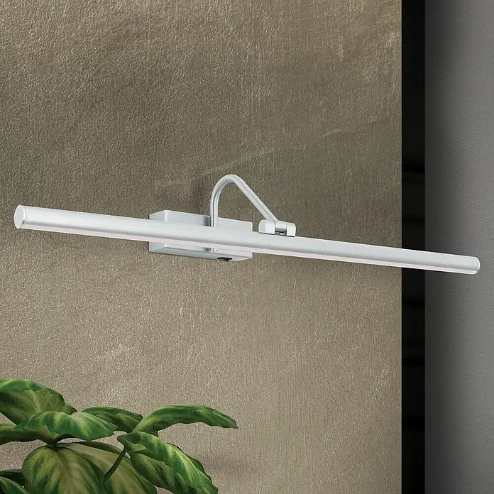 Orion Leuchten Wandleuchte - 12 W, L x B x H: 19 x 60 x 10 cm - Silberne Bilderleuchte aus gebürstetem Aluminium, an einer strukturierten Wand montiert, mit einer Pflanze im Vordergrund.