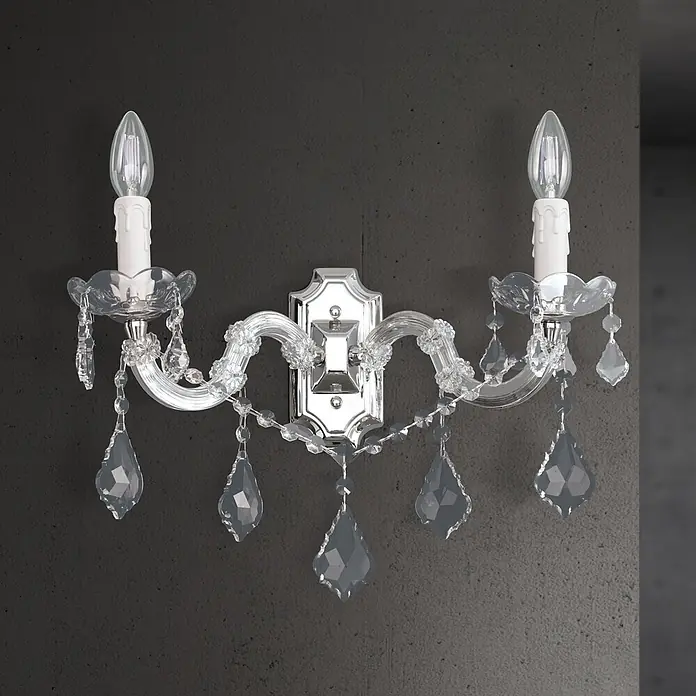 Orion Leuchten Wandleuchte - 40 W, L x B x H: 23 x 36 x 25 cm, E14 - Elegante zweiflammige Kristall-Wandleuchte mit Chromsockel und weißen Kerzenlampen, an einer dunklen strukturierten Wand montiert.