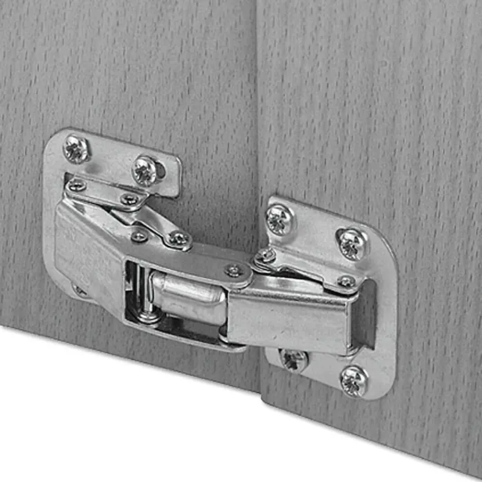 Stabilit Bisagra Easy-On - L x An: 27 x 18 mm - Primer plano de una bisagra metálica de armario sujeta a dos paneles de madera.