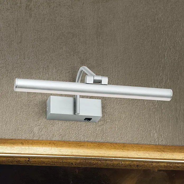 Orion Leuchten Wandleuchte - 6 W, L x B x H: 18,5 x 30 x 10 cm - Gebürstete Silber-Bilderleuchte an strukturierter Wand, die ein goldgerahmtes Kunstwerk beleuchtet.