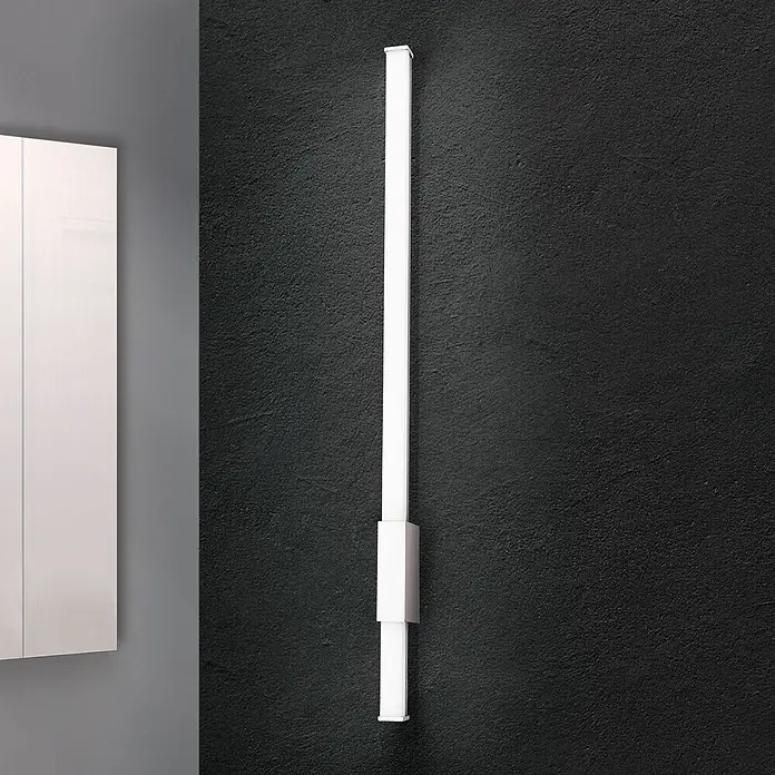 Orion Leuchten Wandleuchte - 13 W, L x B x H: 6,8 x 60,5 x 2,5 cm - Hohe, weiße, rechteckige LED-Wandleuchte vertikal an dunkler Wand neben weißem Schrank montiert.
