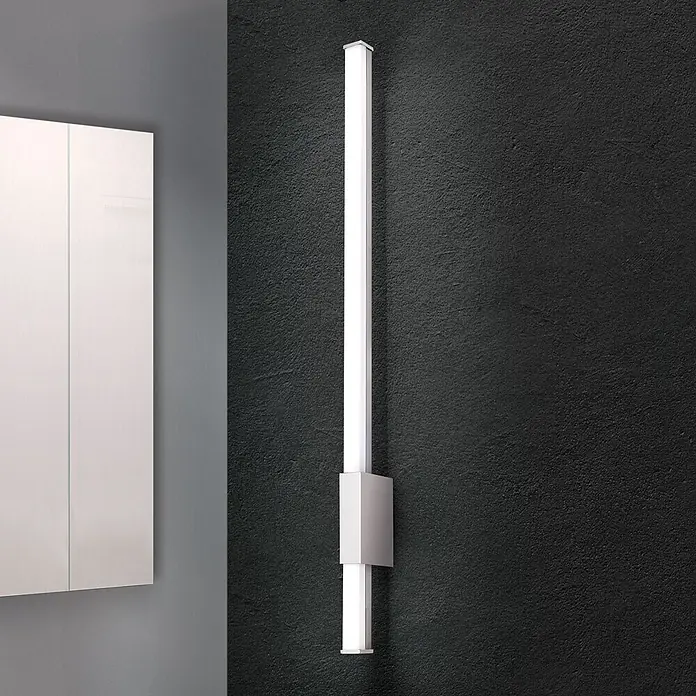 Orion Leuchten Wandleuchte - 13 W, L x B x H: 6,8 x 60,5 x 2,5 cm - Moderne silberne LED-Lichtleiste, vertikal an dunkler Wand neben einem weißen Schrank montiert.