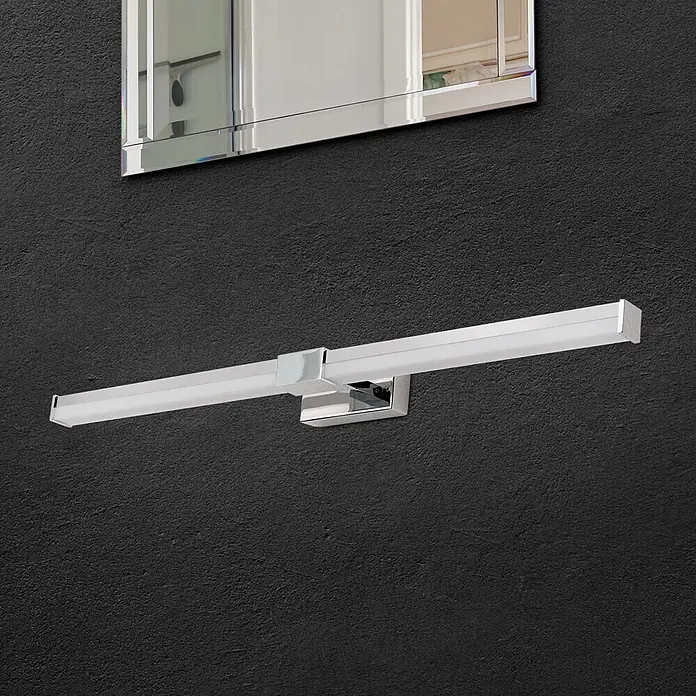 Orion Leuchten Wandleuchte - 13 W, L x B x H: 8 x 55 x 5 cm - Elegante lineare LED-Spiegelleuchte aus Chrom an dunkler Wand unter einem Spiegel montiert.