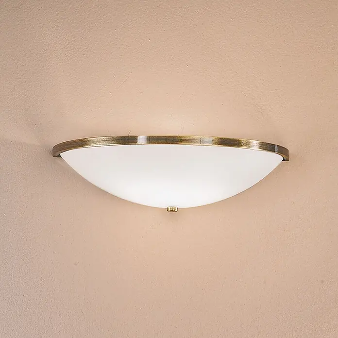 Orion Leuchten Wandleuchte - 40 W, L x B x H: 16 x 31 x 9 cm, E14 - Halbrunde Wandleuchte mit mattweißem Glasdiffusor und antikem Messingrand, an einer Wand montiert.