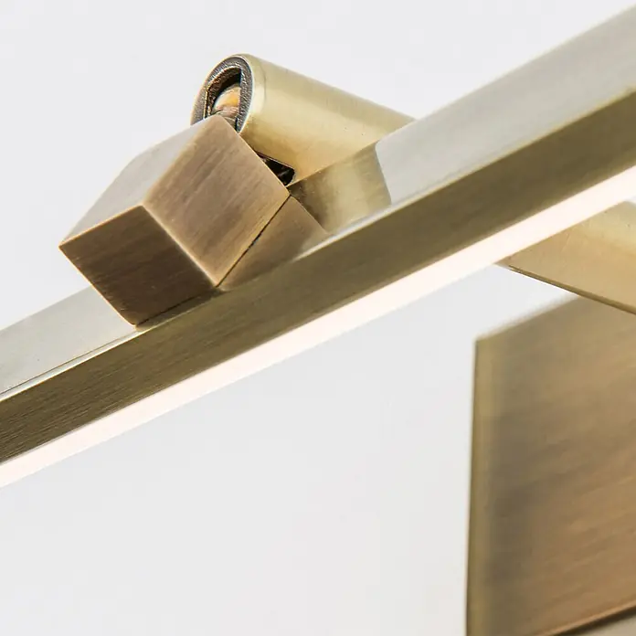 Orion Leuchten Wandleuchte - 10 W, L x B x H: 14,5 x 50 x 6 cm - Nahaufnahme einer gebürsteten Messing-LED-Leuchte mit Gelenk und beleuchteter Stange.
