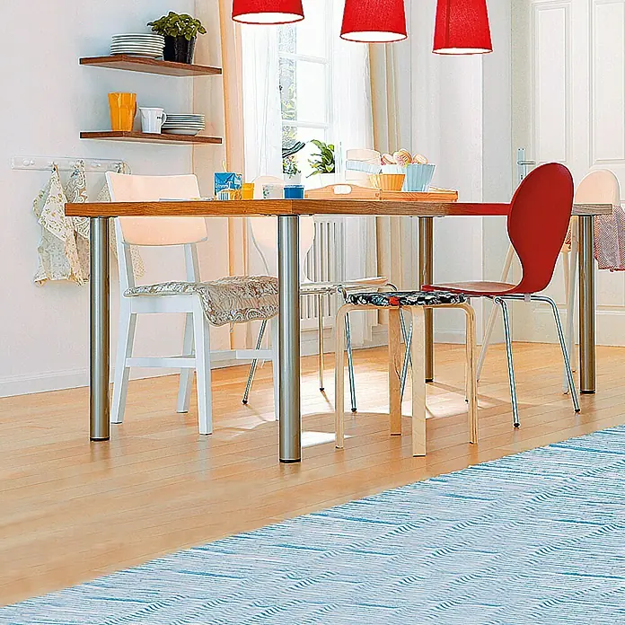 Element System Pata para muebles - Ø x Al: 6 x 110 cm, Capacidad de carga: 75 kg, Acero, Cromo - Un comedor con mesa de madera, sillas y alfombra azul. Lámparas rojas cuelgan del techo, ofreciendo iluminación cálida.