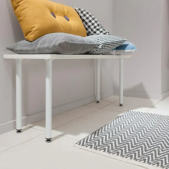 Element System Möbelfuß - Ø x H: 3 x 20 cm, Traglast: 50 kg, Stahl, Edelstahl - Ein weißer Beistelltisch mit Kissen darauf, ideal als Ablagefläche oder dekoratives Element. Das moderne Design passt gut in jeden Raum.